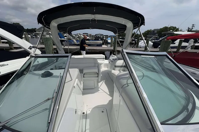 Slide: The Image of 2004 Formula 2800 BR boat with canopy, docked at marina, featuring spacious seating and sleek design. - 15
