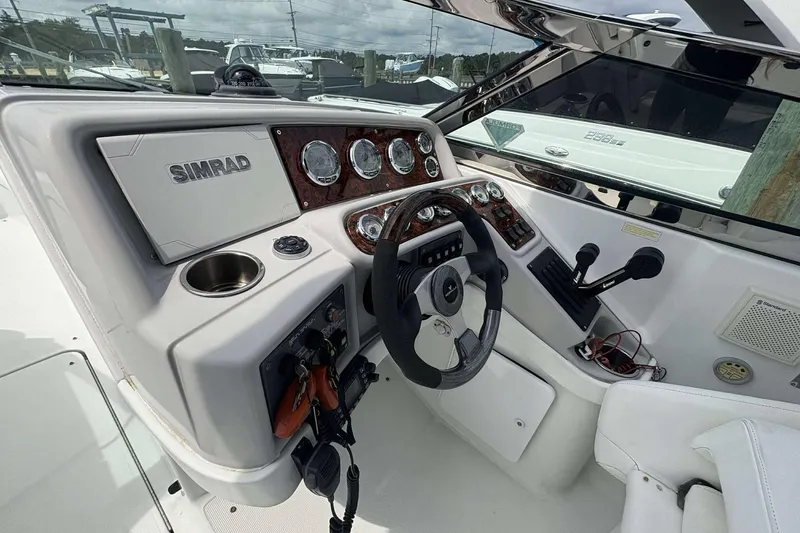 Slide: The Image of 2004 Formula 2800 BR boat dashboard with steering wheel and Simrad navigation system. - 16