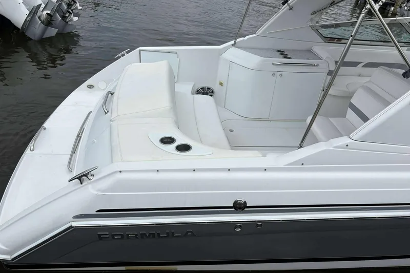 Slide: The Image of 2004 Formula 2800 BR boat with white seating and sleek design, docked on water. - 23