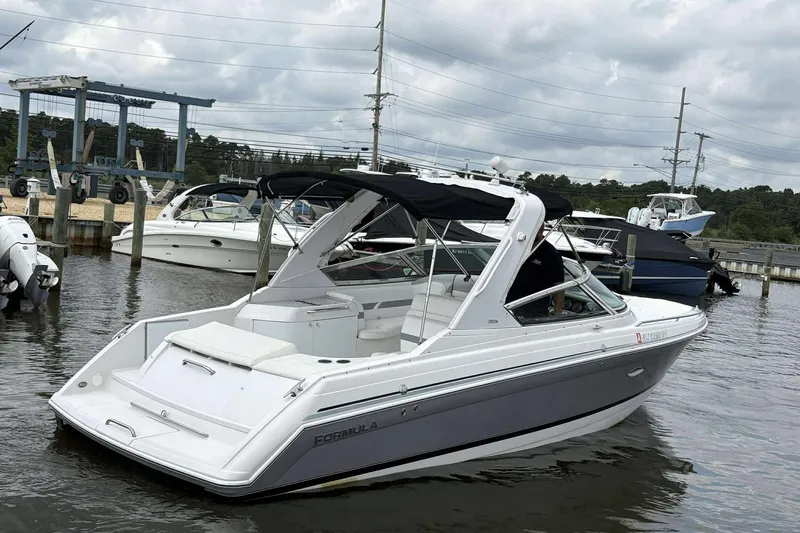 Slide: The Image of 2004 Formula 2800 BR boat docked in marina, overcast sky, other boats nearby. - 9