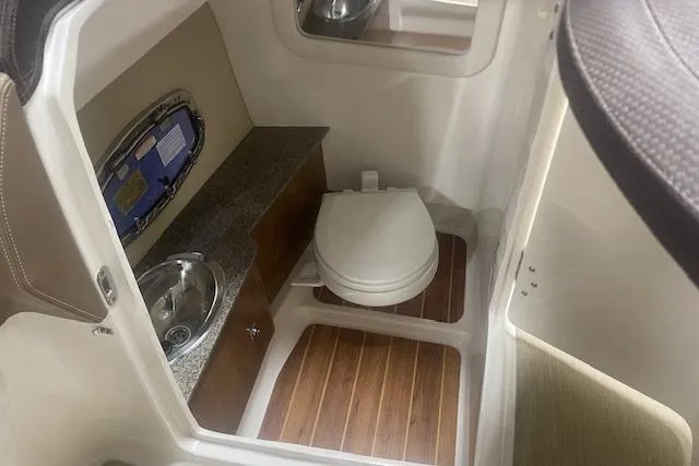Slide: The Image of 2014 Chaparral 257 SSX boat interior with toilet and sink. - 12