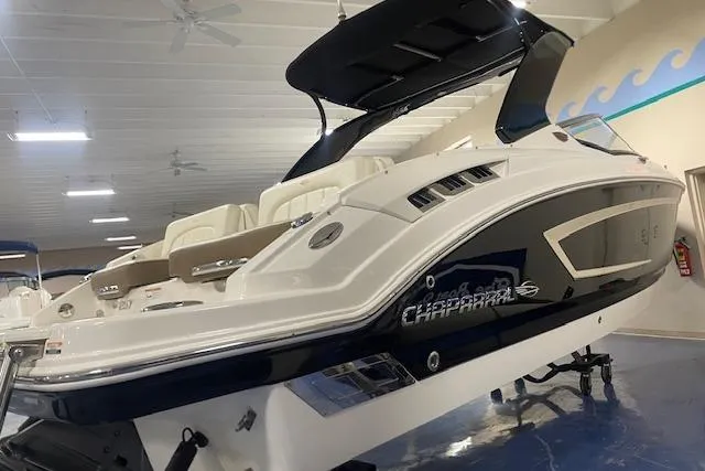 Slide: The Image of 2014 Chaparral 257 SSX boat in showroom, sleek design, white and navy exterior. - 2
