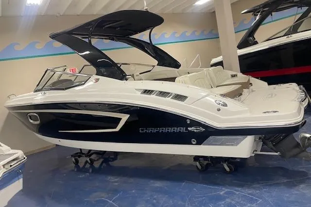 Slide: The Image of 2014 Chaparral 257 SSX boat in showroom, sleek design, black and white exterior. - 3