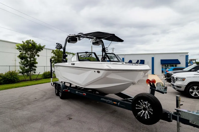 Slide: The Image of 2026 Nautique Super Air Nautique GS22 boat on trailer, parked outdoors. - 13