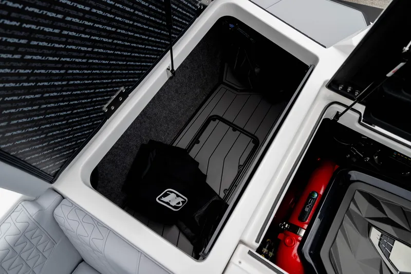 Slide: The Image of 2026 Nautique Super Air Nautique GS22 storage compartment and engine detail. - 19