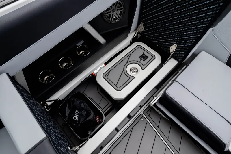 Slide: The Image of 2026 Nautique Super Air Nautique GS22 interior storage with cooler and cup holders. - 25