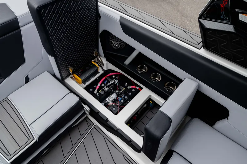 Slide: The Image of 2026 Nautique Super Air Nautique GS22 interior with open storage compartment and cup holders. - 31