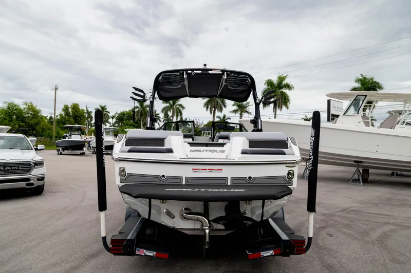 Slide: The Image of 2026 Nautique Super Air Nautique GS22 boat, rear view, parked outdoors. - 4