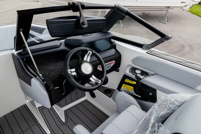 Slide: The Image of 2026 Nautique Super Air Nautique GS22 boat interior with modern steering and dashboard controls. - 46