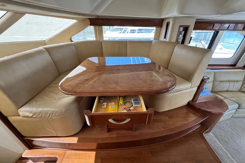 Slide: The Image of Luxurious seating area on 2009 Ovation 52 yacht with wooden table and storage drawer. - 26
