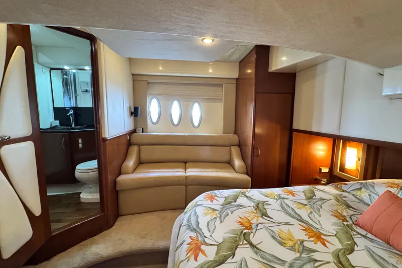 Slide: The Image of Luxurious 2009 Ovation 52 yacht interior with cozy seating, floral bedding, and elegant wood finishes. - 37