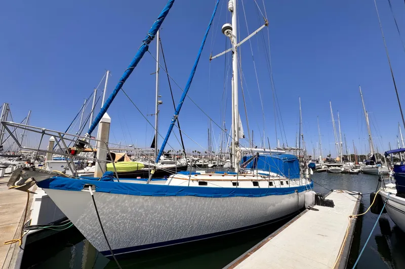 Slide: The Image of 1982 Kelly Peterson 46 sailboat docked in a marina under clear blue skies. - 1