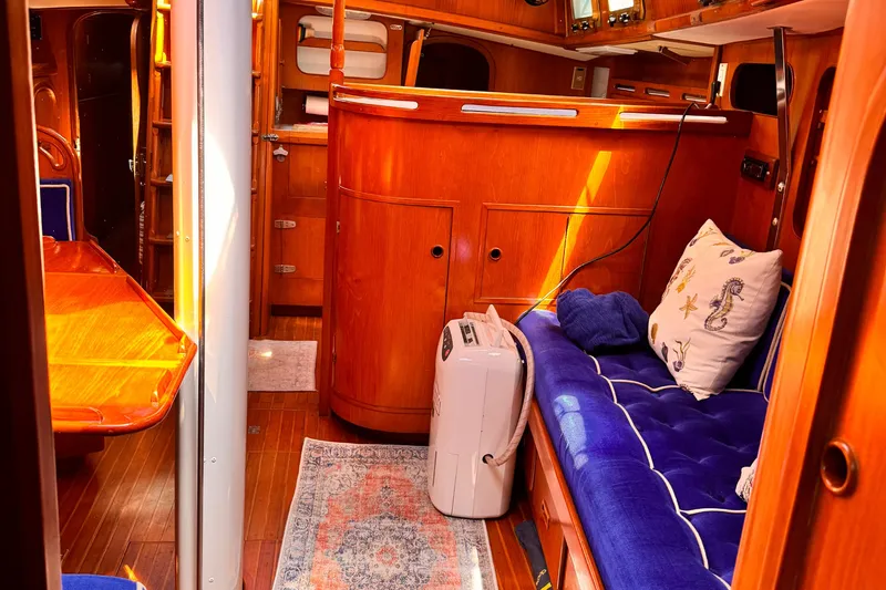 Slide: The Image of Interior of 1982 Kelly Peterson 46 yacht with wooden furnishings and blue seating. - 11