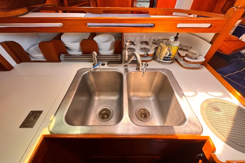 Slide: The Image of Galley sink area in 1982 Kelly Peterson 46 yacht, featuring dual basins and wooden cabinetry. - 13