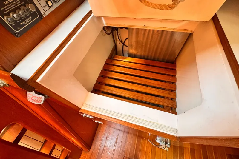 Slide: The Image of Interior of 1982 Kelly Peterson 46 sailboat with wooden flooring and storage compartment. - 15
