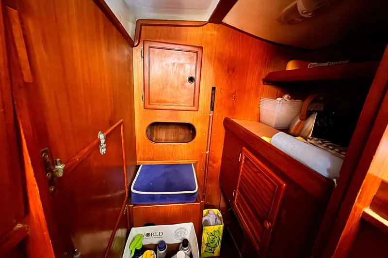 Slide: The Image of Interior of 1982 Kelly Peterson 46 sailboat with wooden cabinetry and storage shelves. - 17