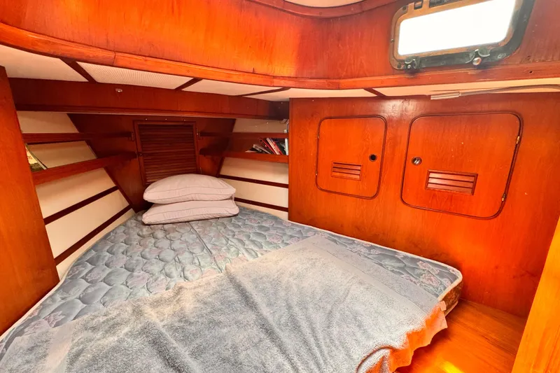 Slide: The Image of Cozy cabin interior of 1982 Kelly Peterson 46 sailboat with wooden finish and bedding. - 19