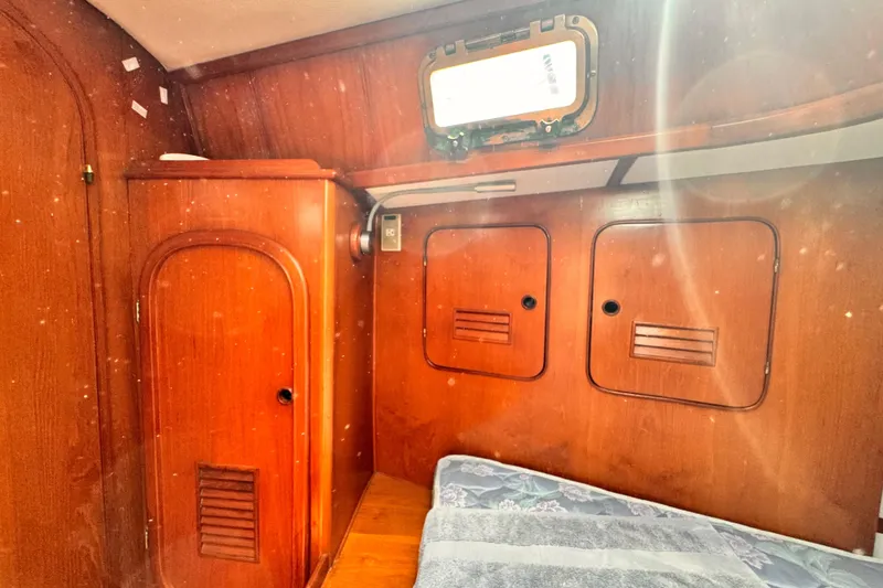 Slide: The Image of Cozy wooden cabin interior of 1982 Kelly Peterson 46 sailboat, featuring storage and bedding. - 20