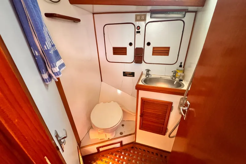 Slide: The Image of 1982 Kelly Peterson 46 yacht bathroom with toilet, sink, and wooden accents. - 21