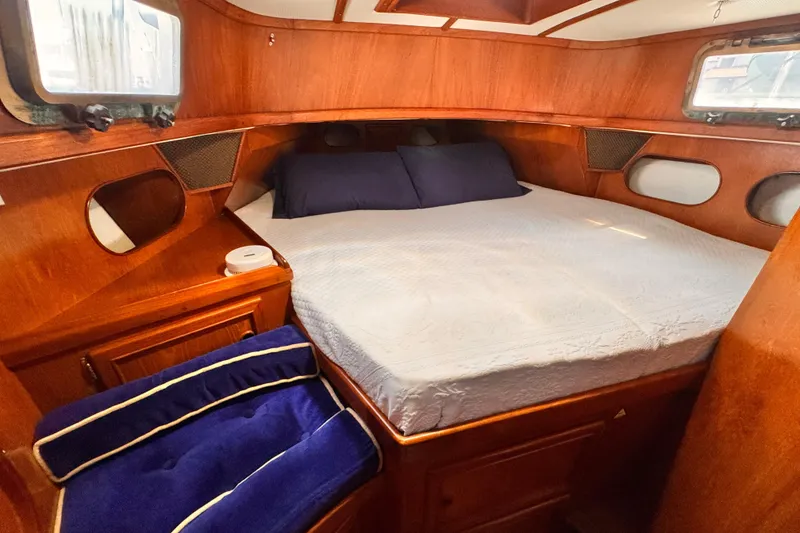 Slide: The Image of Cozy cabin interior of 1982 Kelly Peterson 46 sailboat with wooden finish and comfortable bedding. - 23