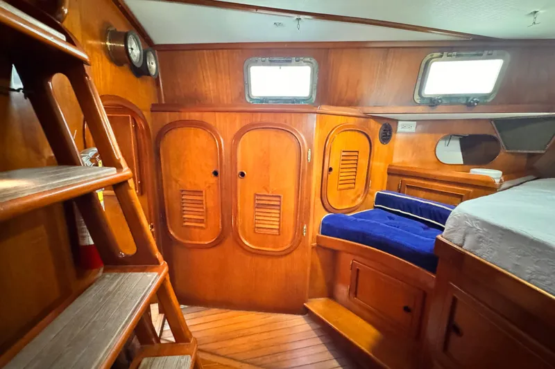 Slide: The Image of Interior of 1982 Kelly Peterson 46 sailboat with wooden cabinetry and blue seating. - 24
