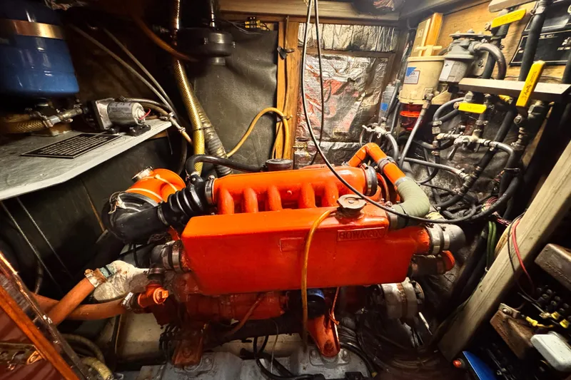 Slide: The Image of Engine room of 1982 Kelly Peterson 46 sailboat with red engine components. - 27