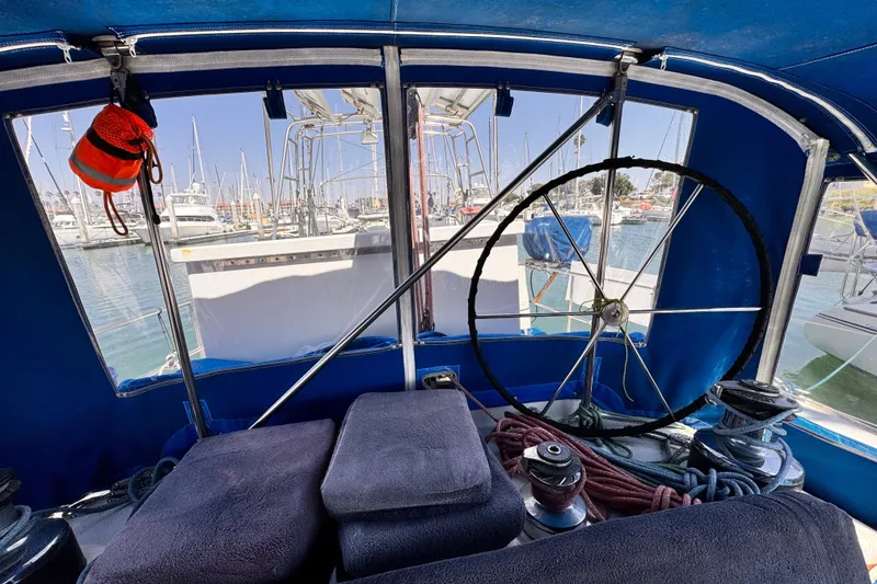 Slide: The Image of Interior view of a 1982 Kelly Peterson 46 sailboat cockpit with marina background. - 30