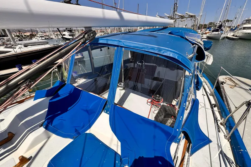 Slide: The Image of 1982 Kelly Peterson 46 sailboat with blue canopy docked in marina. - 38