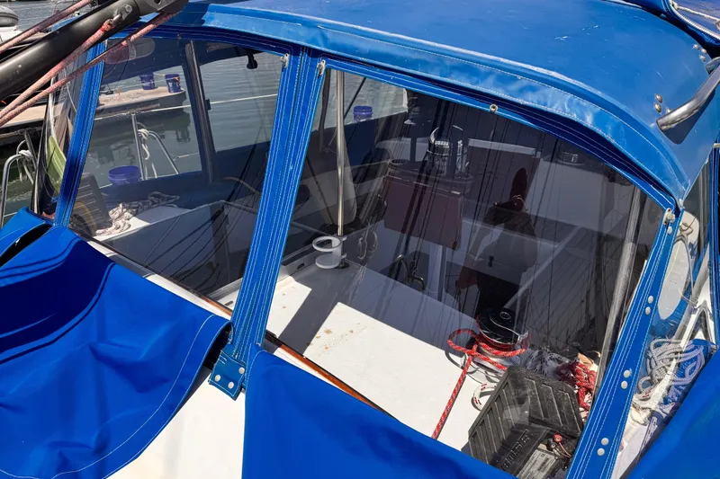 Slide: The Image of 1982 Kelly Peterson 46 sailboat cockpit with blue canopy and visible ropes. - 39