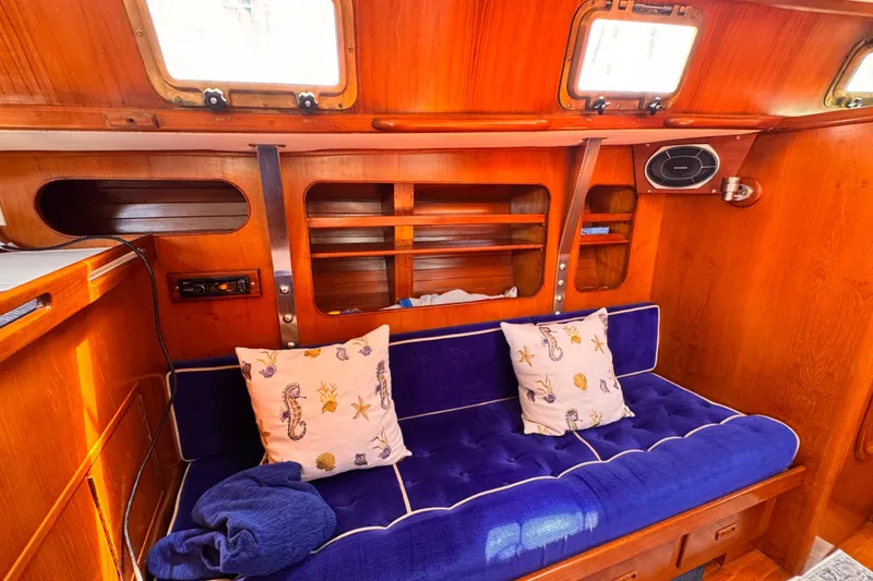 Slide: The Image of Interior of 1982 Kelly Peterson 46 yacht with blue cushioned seating and nautical-themed pillows. - 4