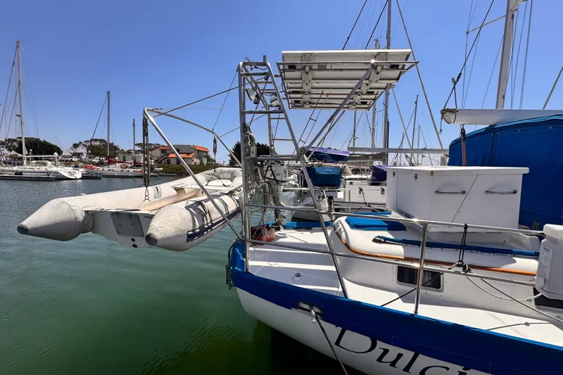 Slide: The Image of Sailboat Kelly Peterson 46, 1982 model, docked with dinghy and solar panels. - 43