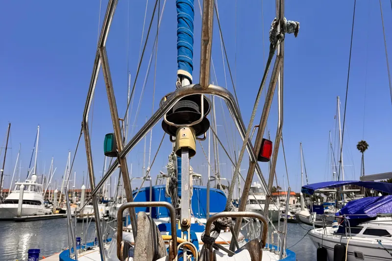 Slide: The Image of Sailboat rigging on a 1982 Kelly Peterson 46 in a marina, clear blue sky. - 47
