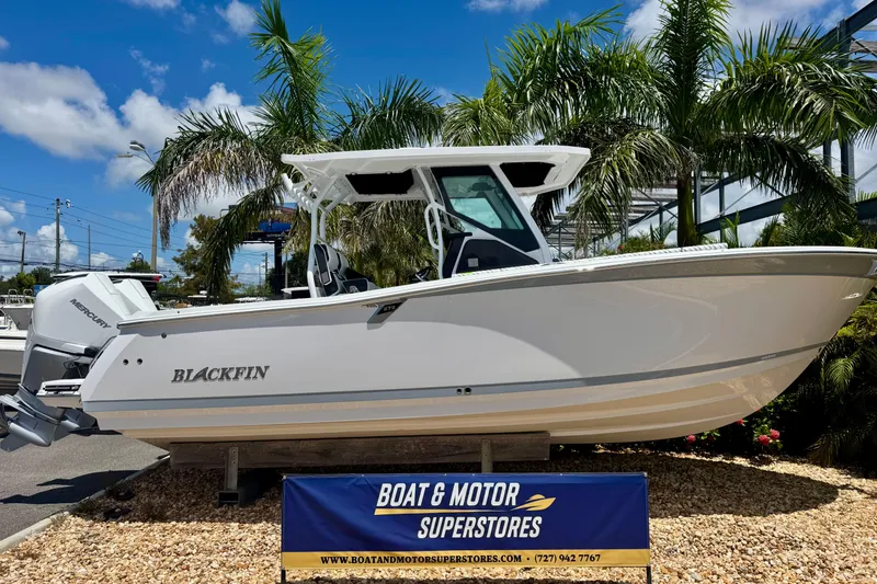 The Image of 2026 Blackfin 272 CC boat displayed at dealership, surrounded by palm trees. - 0