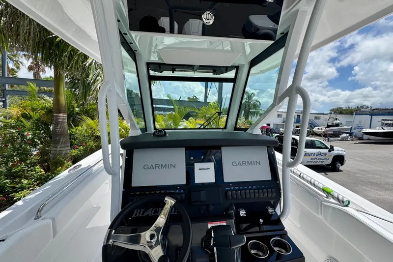 Slide: The Image of 2026 Blackfin 272 CC boat cockpit with Garmin displays and steering wheel. - 17