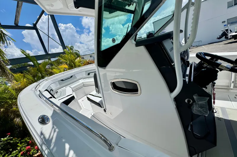 Slide: The Image of 2026 Blackfin 272 CC boat interior with modern helm and seating, under sunny skies. - 18