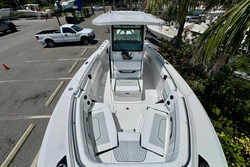 Slide: The Image of 2026 Blackfin 272 CC boat with spacious seating, parked near palm trees. - 21