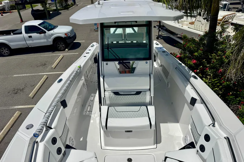 Slide: The Image of 2026 Blackfin 272 CC boat, sleek design, spacious deck, parked outdoors. - 23