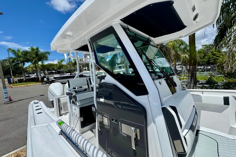 Slide: The Image of 2026 Blackfin 272 CC boat with sleek design, docked under clear blue sky. - 26