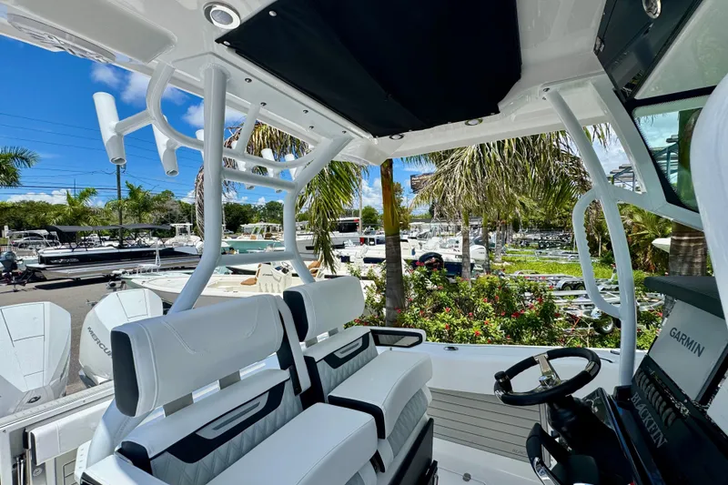 Slide: The Image of 2026 Blackfin 272 CC boat interior with white seating and palm trees in the background. - 30