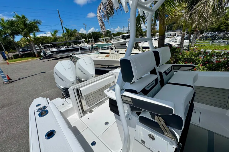 Slide: The Image of 2026 Blackfin 272 CC boat with dual Mercury engines, docked near palm trees. - 31