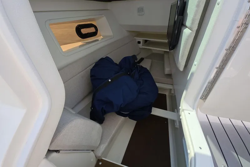 Slide: The Image of 2020 Sea Ray SLX 350 cabin interior with seating and window view. - 12