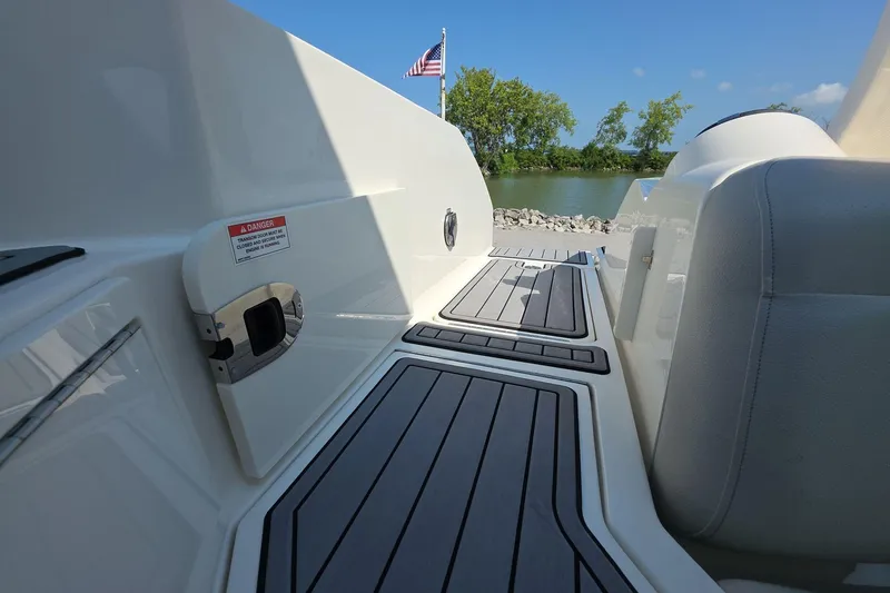 Slide: The Image of 2020 Sea Ray SLX 350 boat deck with seating, American flag, and scenic water view. - 13