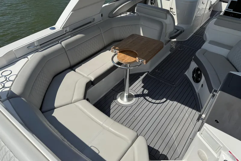 Slide: The Image of Luxurious 2020 Sea Ray SLX 350 boat interior with elegant seating and wooden table. - 16