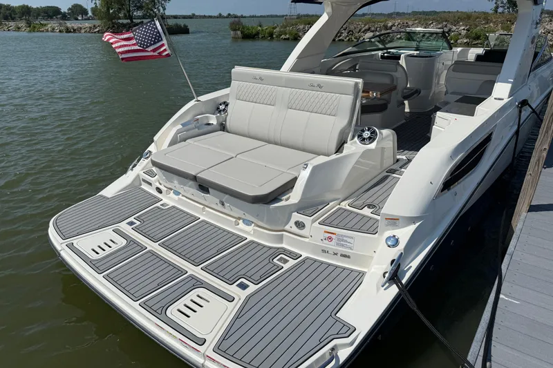 Slide: The Image of 2020 Sea Ray SLX 350 boat docked, featuring spacious seating and American flag. - 26