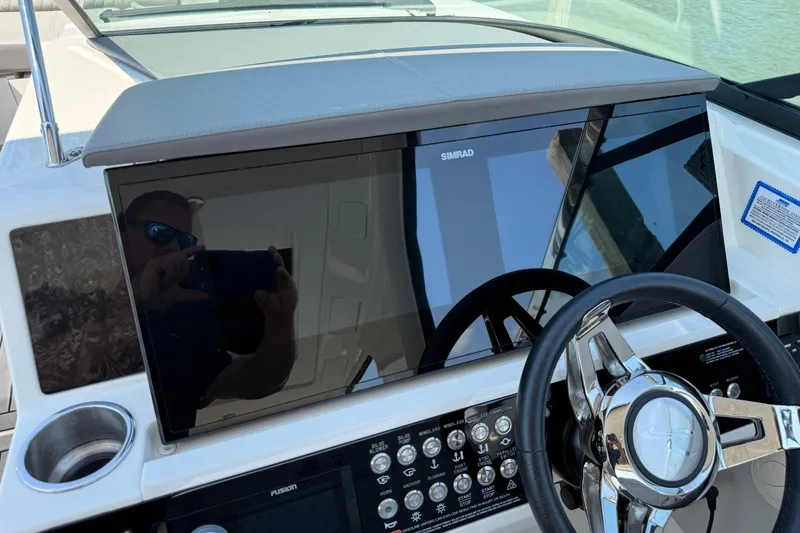 Slide: The Image of 2020 Sea Ray SLX 350 dashboard with Simrad display and steering wheel. - 29