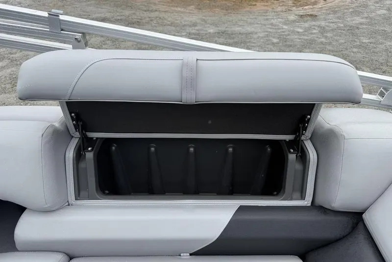 Slide: The Image of 2026 Sun Tracker Party Barge 22 DLX storage compartment with open seat cushion. - 21