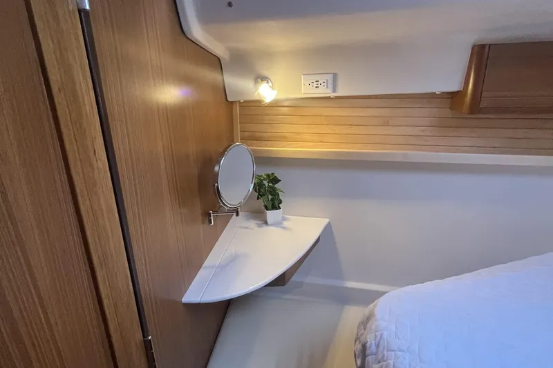 Slide: The Image of Cozy Catalina 386 yacht interior with wooden paneling, mirror, and small plant on a shelf. - 12