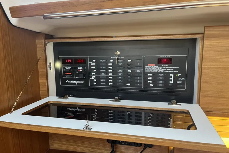 Slide: The Image of Electrical control panel on a 2026 Catalina 386 yacht, featuring various switches and displays. - 19