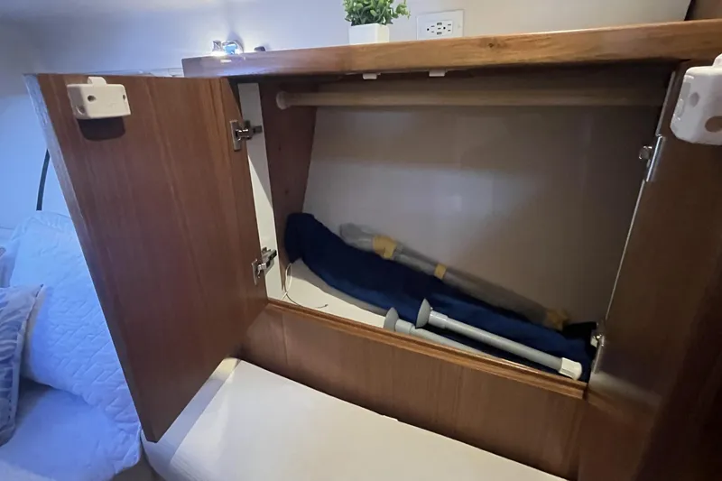 Slide: The Image of Open wooden cabinet in Catalina 386 yacht, 2026 model, with stored items inside. - 23