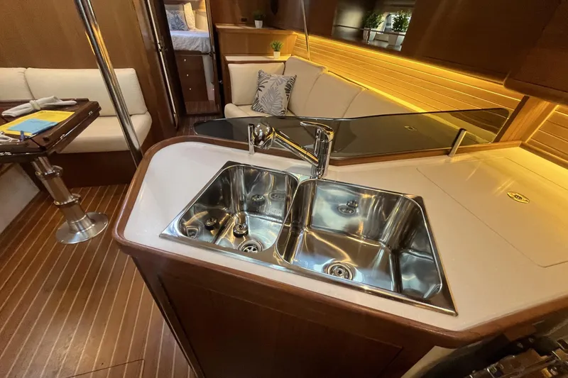 Slide: The Image of Luxurious Catalina 386 yacht interior with modern kitchen sink, cozy seating, and elegant wood finish. - 8